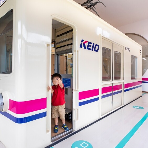 京王れーるランドの車掌体験で実物車両から顔を出す子ども