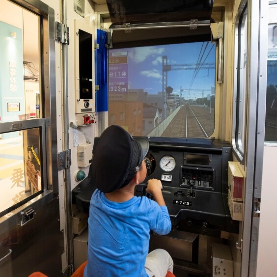 京王れーるランドの運転体験シミュレーターを操縦する子ども