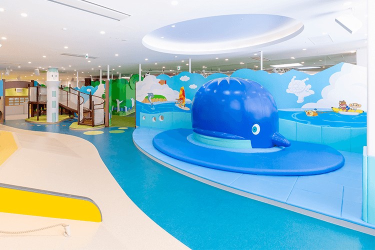 くじらの滑り台がある海をテーマにした屋内の遊びフロア