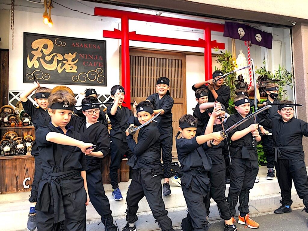 忍者衣装をまとった参加者たちと忍者カフェ浅草の店構え