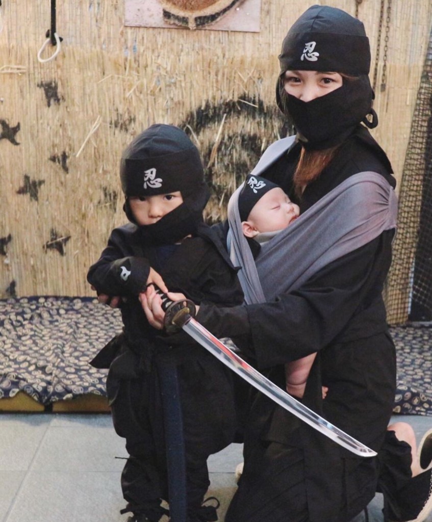 忍者衣装を着た母親と幼児、抱っこ紐の赤ちゃん