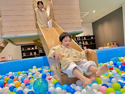 おふろcafeハレニワの湯のキッズパークでボールプールのすべり台を滑る子ども