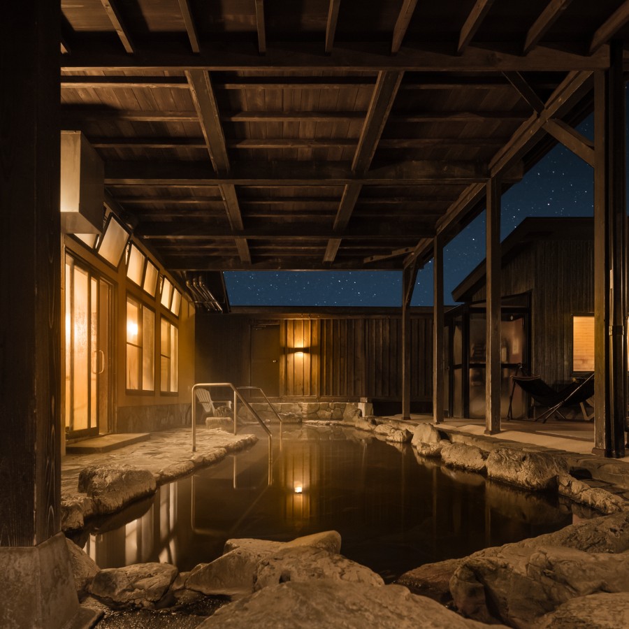 木の屋根に覆われた夜の露天風呂