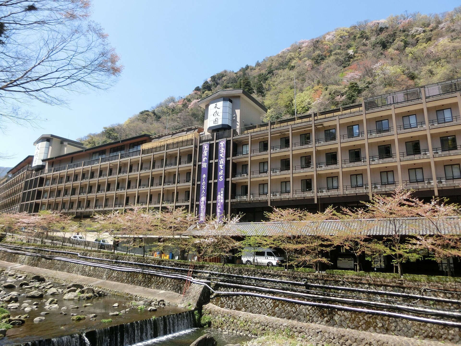 箱根湯本温泉 天成園の外観。早川沿いに建つ本館と桜