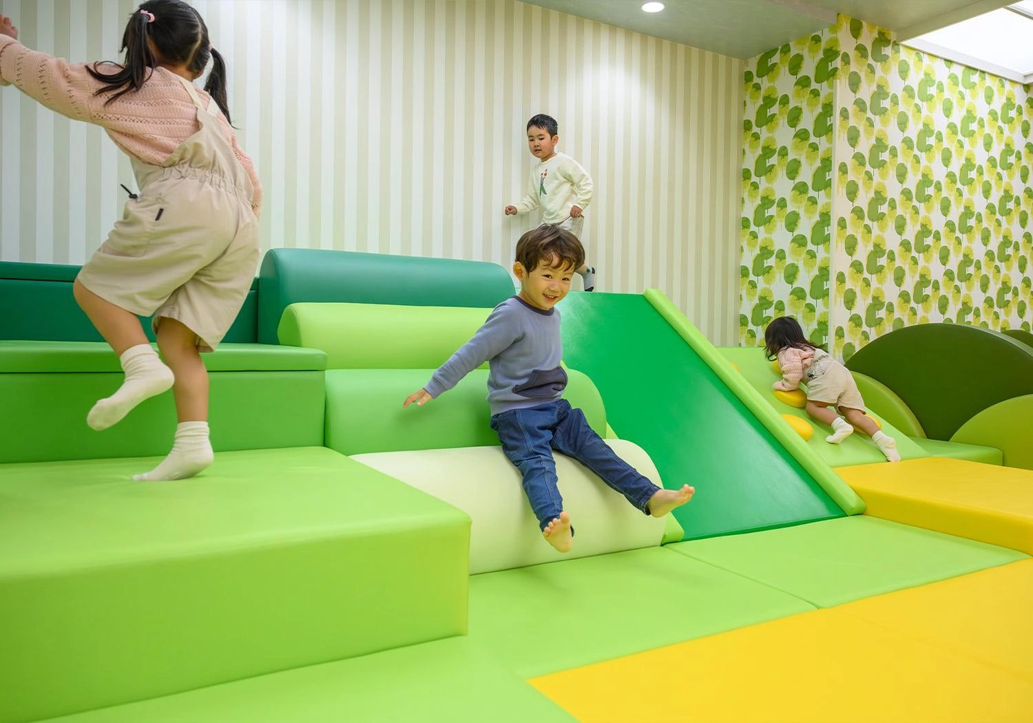 ATAMI KIDS PARKのわんぱく山ゾーンで滑り台を楽しむ子ども