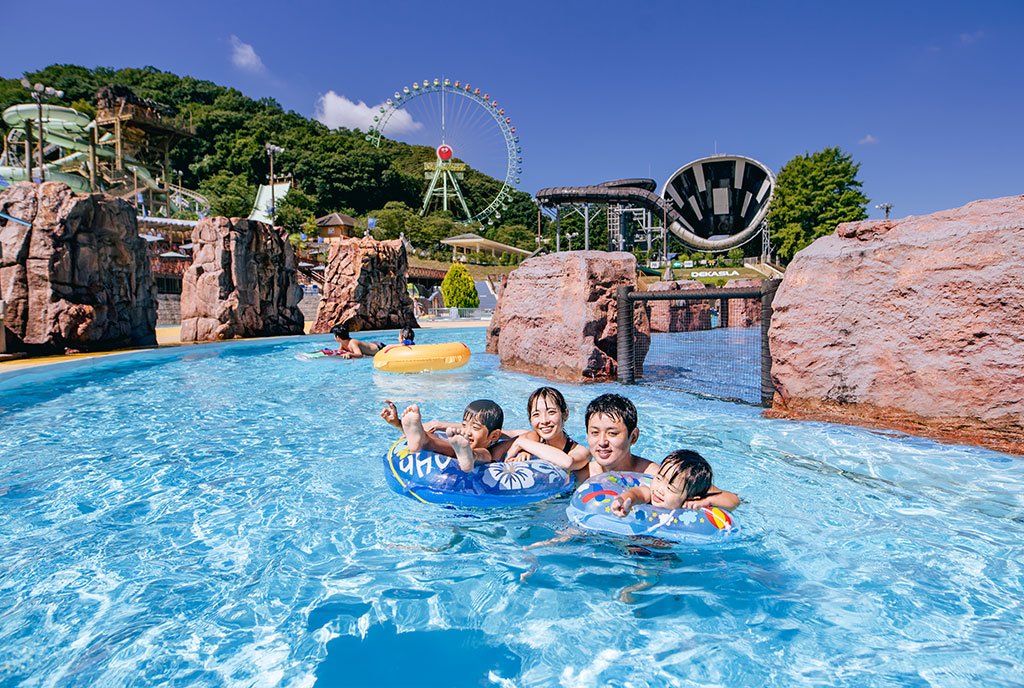 東京サマーランドの流れるプール「グレートジャーニー」で浮き輪に乗って遊ぶ家族