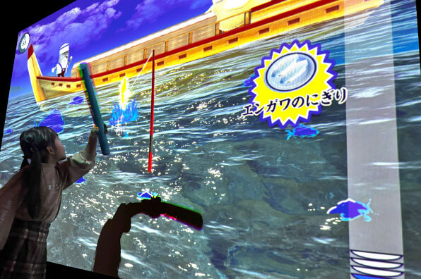 リトルプラネットのARアトラクション「SUSHI FISHING!」で遊ぶ子ども