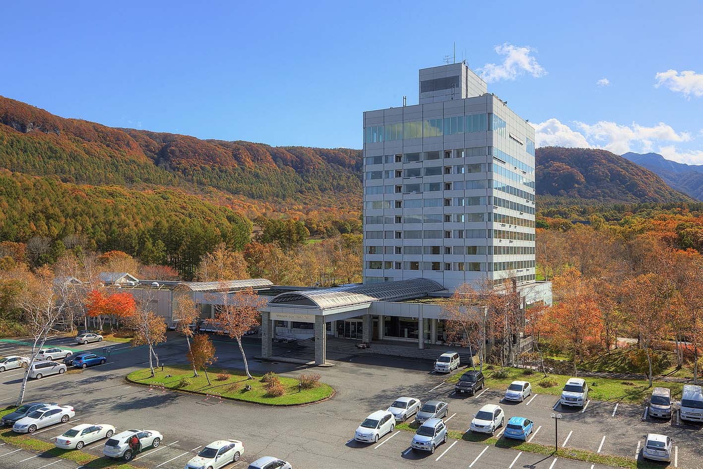 水上高原ホテル200の全景。高原に立つホテルと秋の山