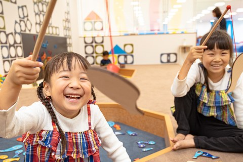 木の遊具コーナーで笑う女の子