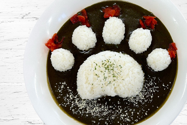 黒いルウにご飯でクマの足あとをかたどったカレー
