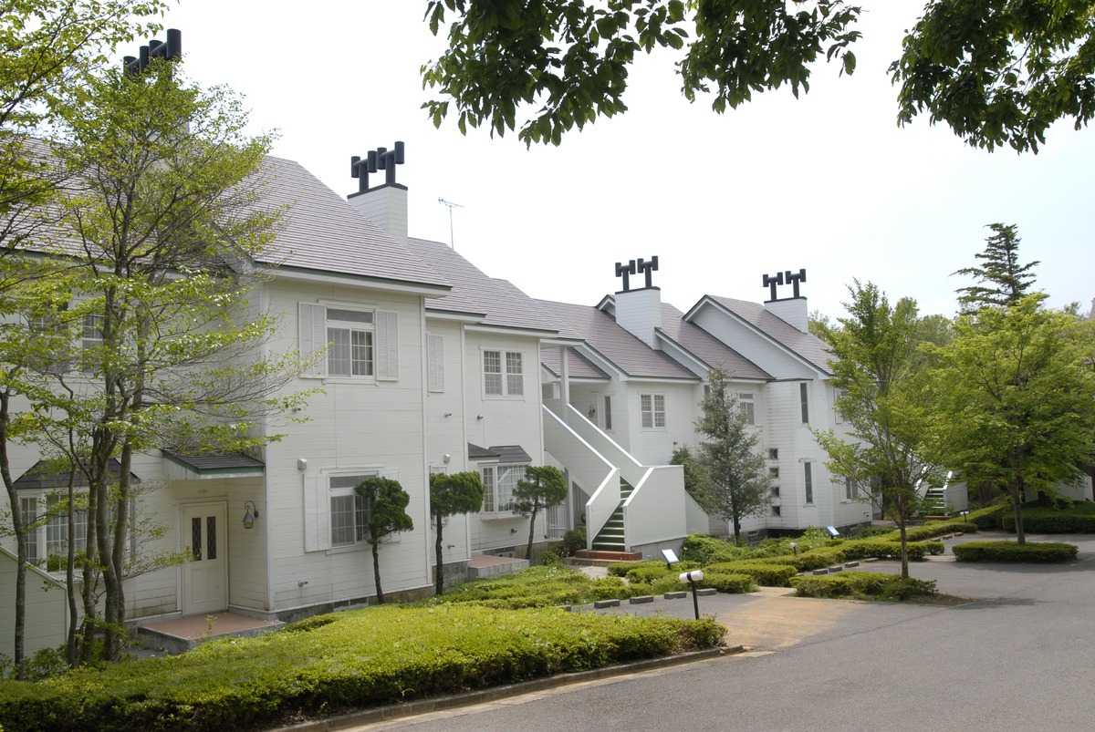 白い外壁の2階建てコテージ