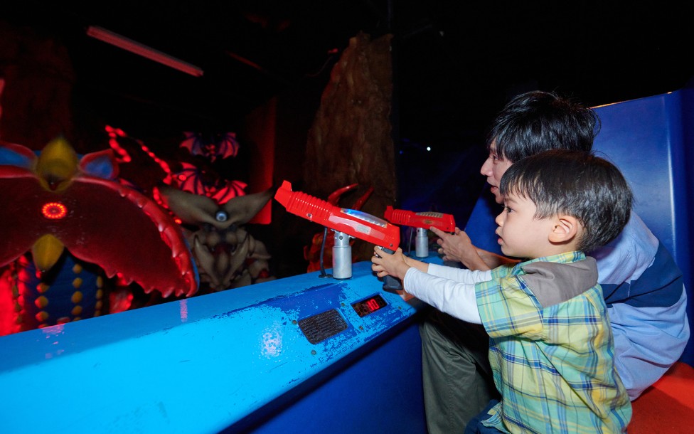 浜名湖パルパル 屋内のドラゴンファイターで光線銃を構える父と男の子