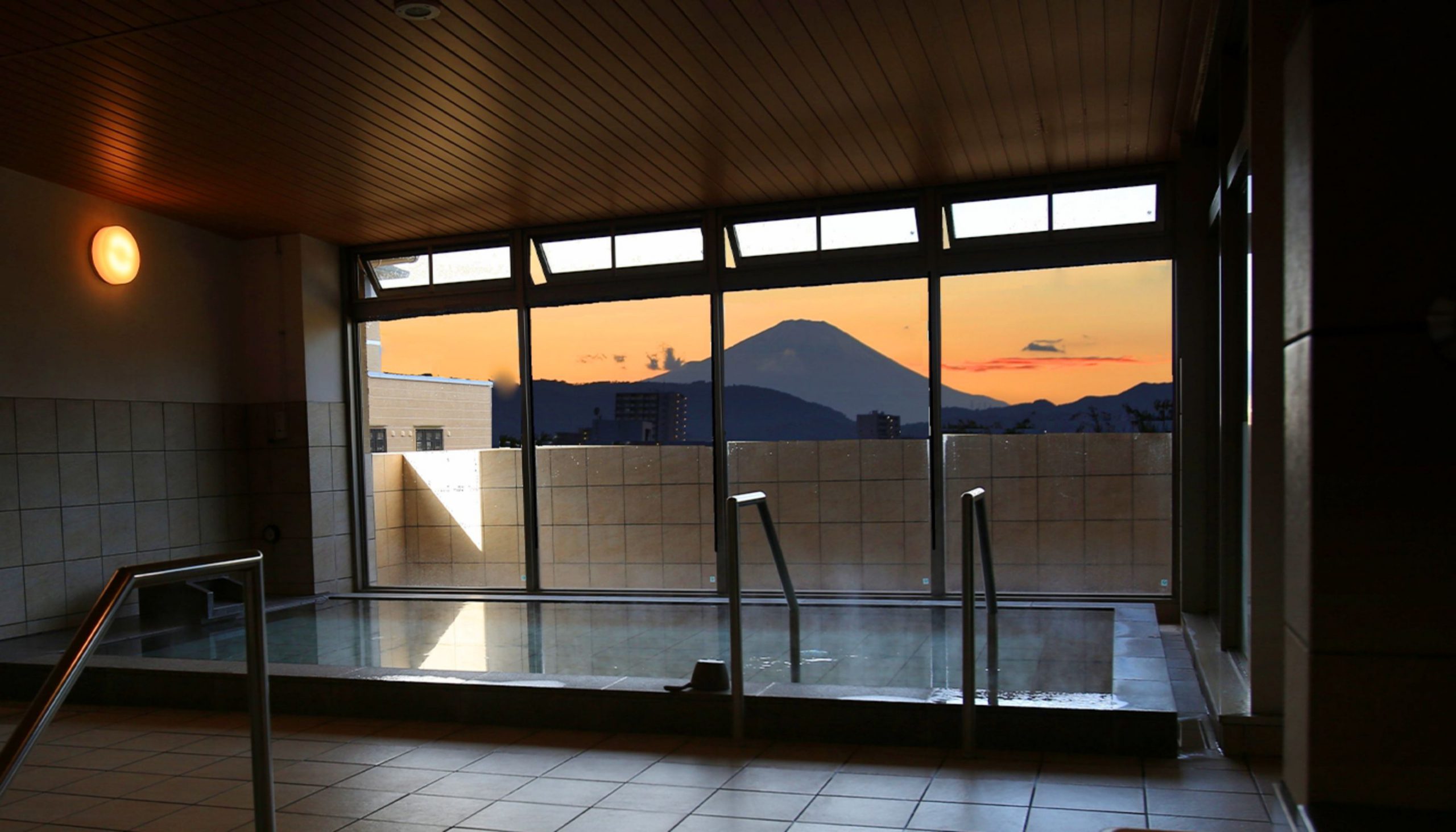 浴室の窓の向こうに見える夕暮れの富士山