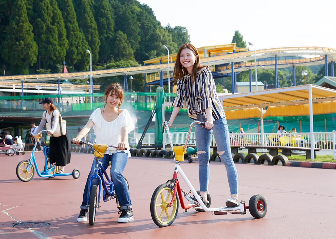 変わり種自転車の広場で大きな車輪のキックバイクに乗る来園者