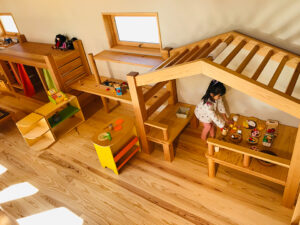 木製の小屋型プレイハウスで遊ぶ女の子