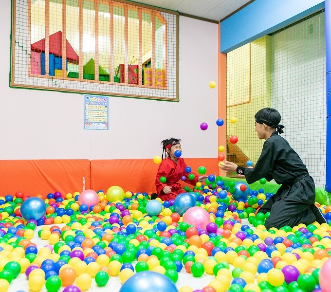 キッズルームのボールプールで遊ぶ子ども