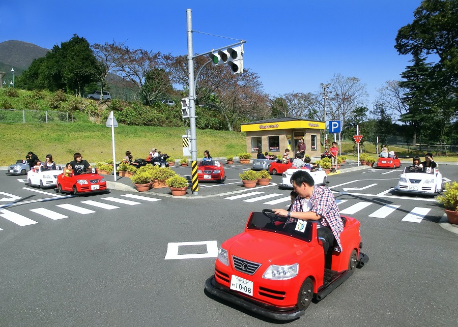 キッズ・ドライビング・スクールで信号のある道路を走る子ども用の車