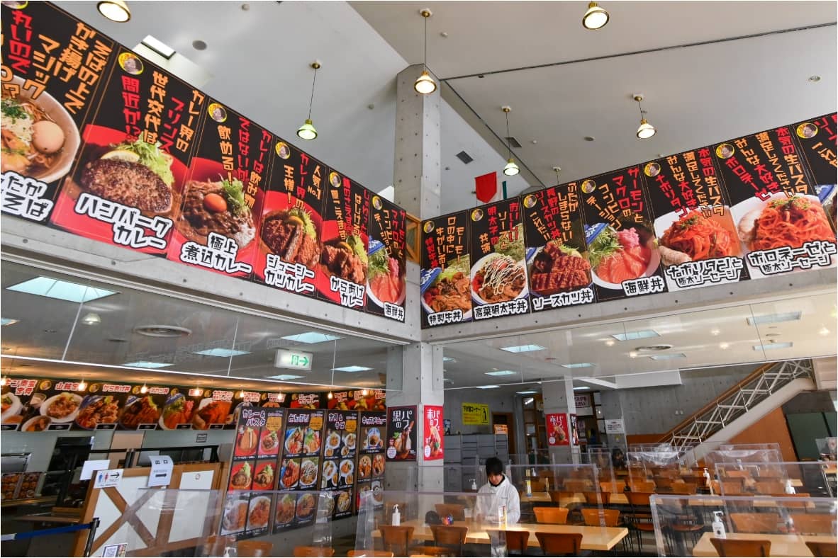 吹き抜けにメニューが並ぶレストランロッソの店内