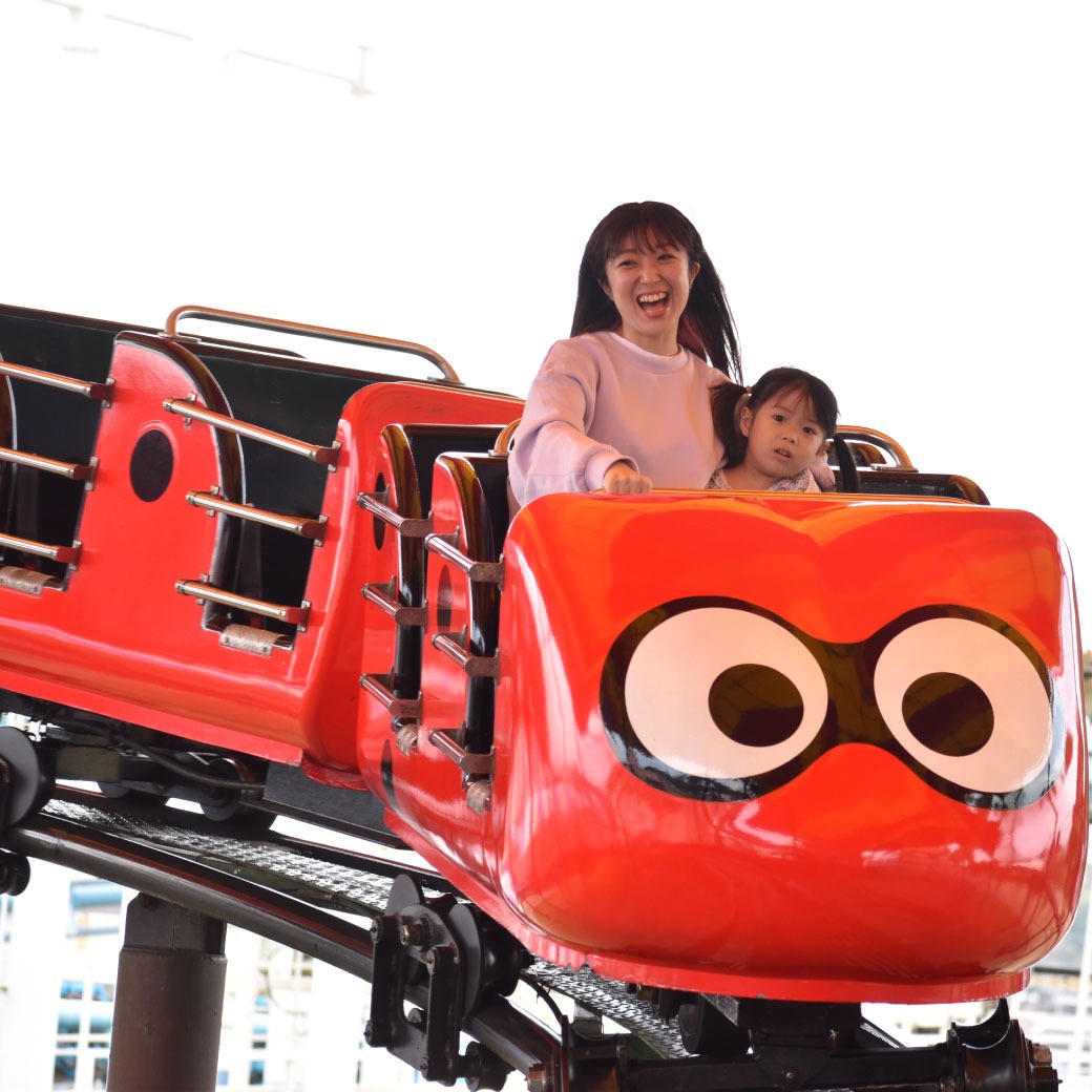 グリーンランド てんとう虫コースターに乗る母親と小さな子ども