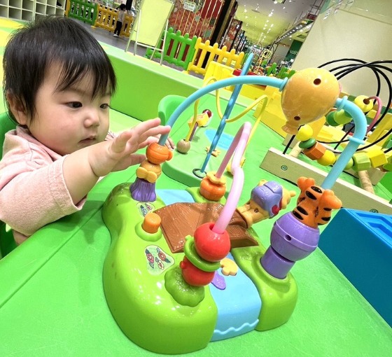 ベビーコーナーで知育玩具を触る赤ちゃん