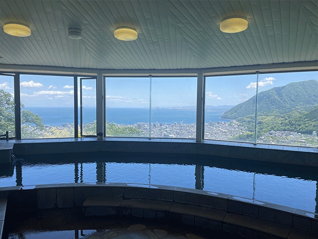 大きな窓から別府湾を見下ろす絶景の湯の浴槽