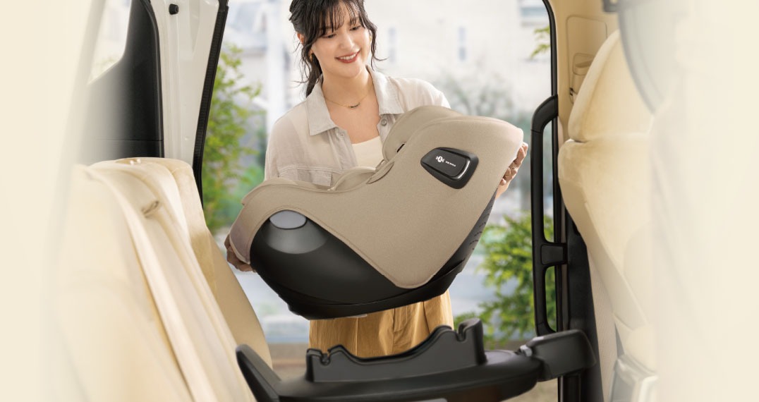 車に付けたベースへクルリラ エックス プラスのシートを載せる女性