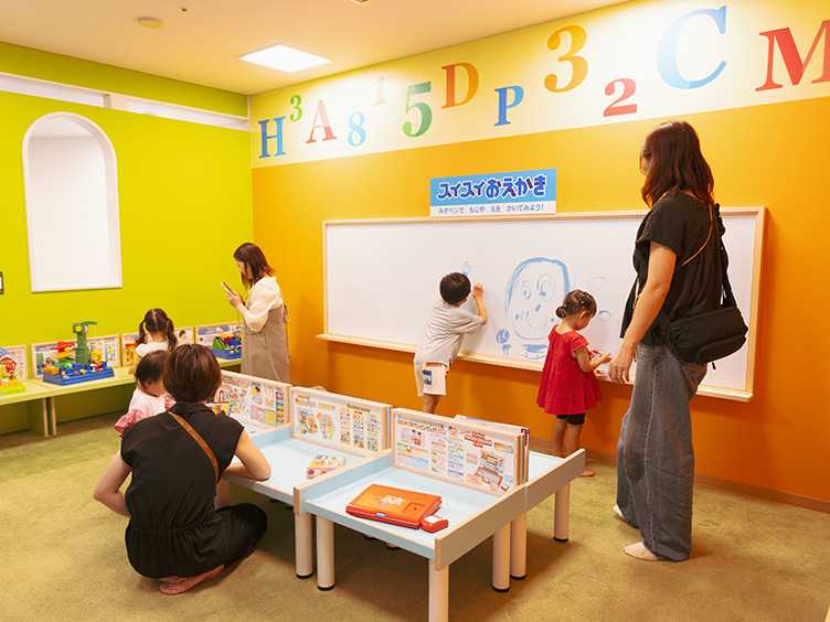 ホワイトボードにお絵かきする子どもたち