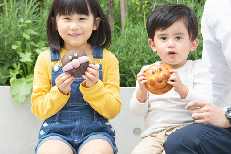 キャラクターの顔のパンを持つ子ども2人