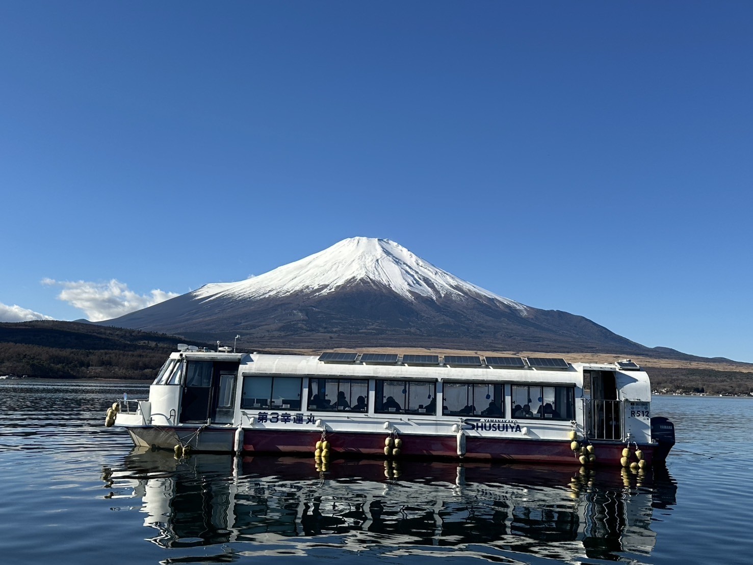 雪をかぶった富士山の前に浮かぶSHUSUIYAのドーム船 第3幸運丸