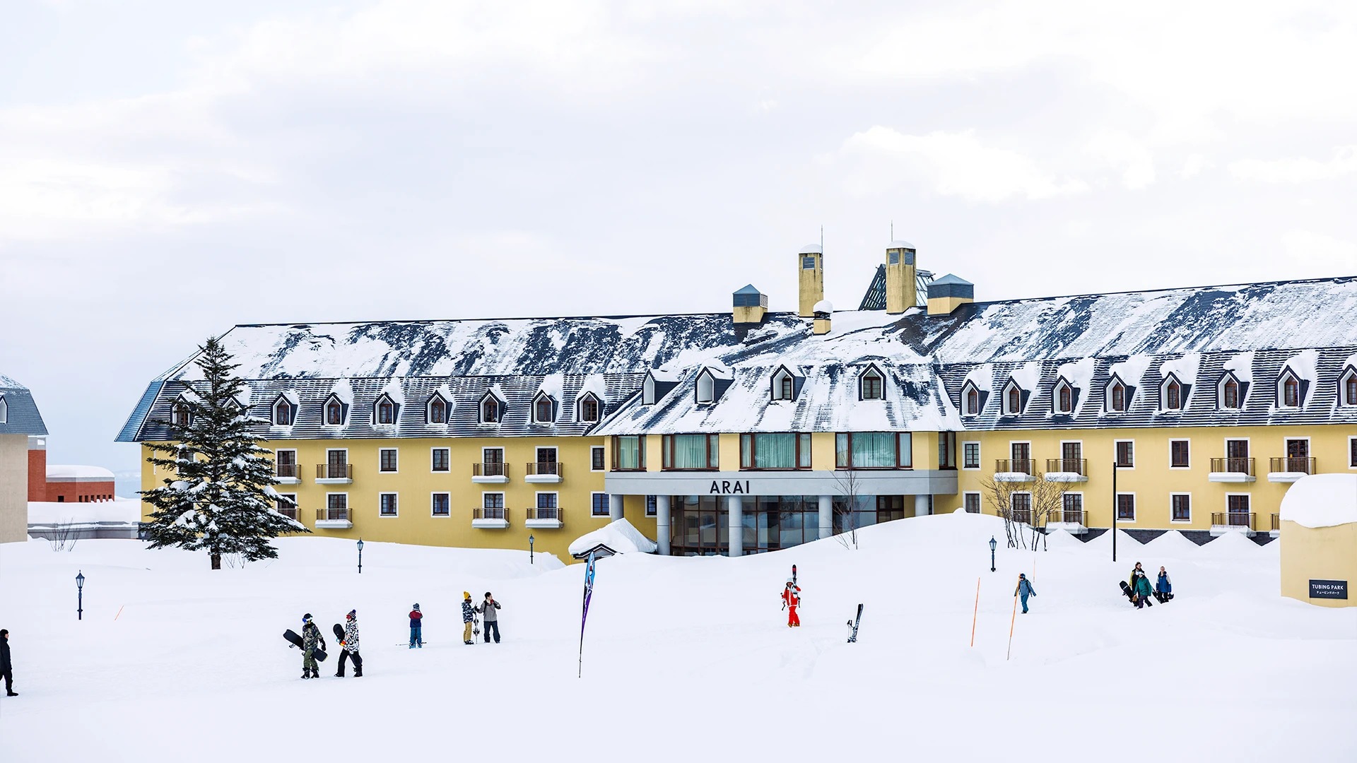 雪に覆われたゲレンデ前に建つロッテアライリゾートのアライ棟
