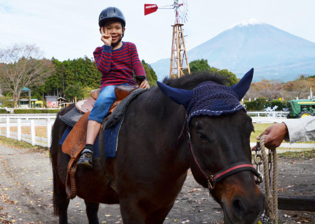 富士山を背に引き馬に乗る男の子