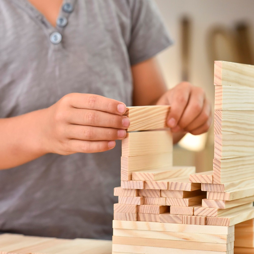 カプラの板を組んで建物を作る子どもの手元