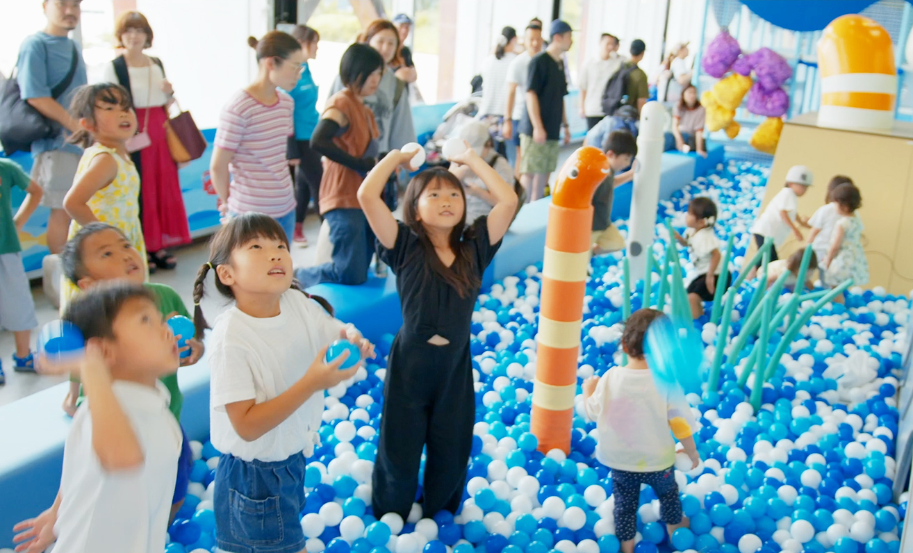 青と白のボールプールで遊ぶ子どもたち